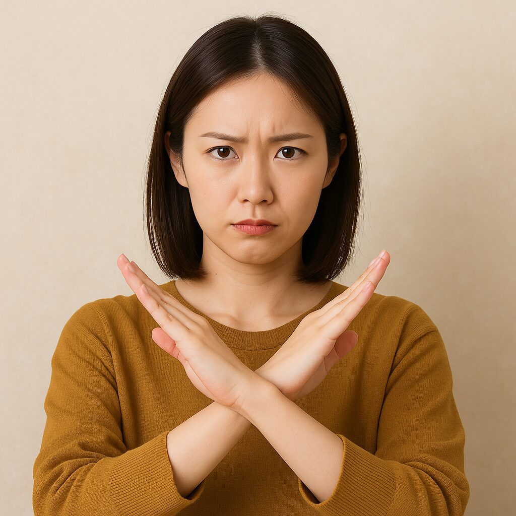 「両手でバツ印を作り、風水的にNGなアイテムを注意している女性」