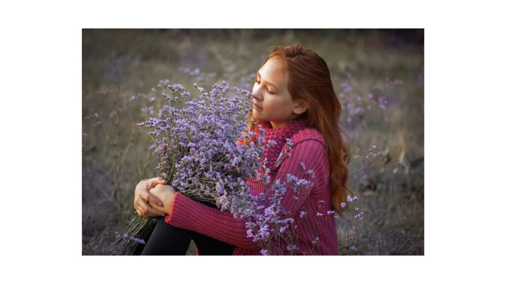 ラベンダーの花束を抱きしめ、穏やかな表情で目を閉じる女性。植物に感謝の気持ちを伝えることで、癒しのエネルギーが循環している様子。