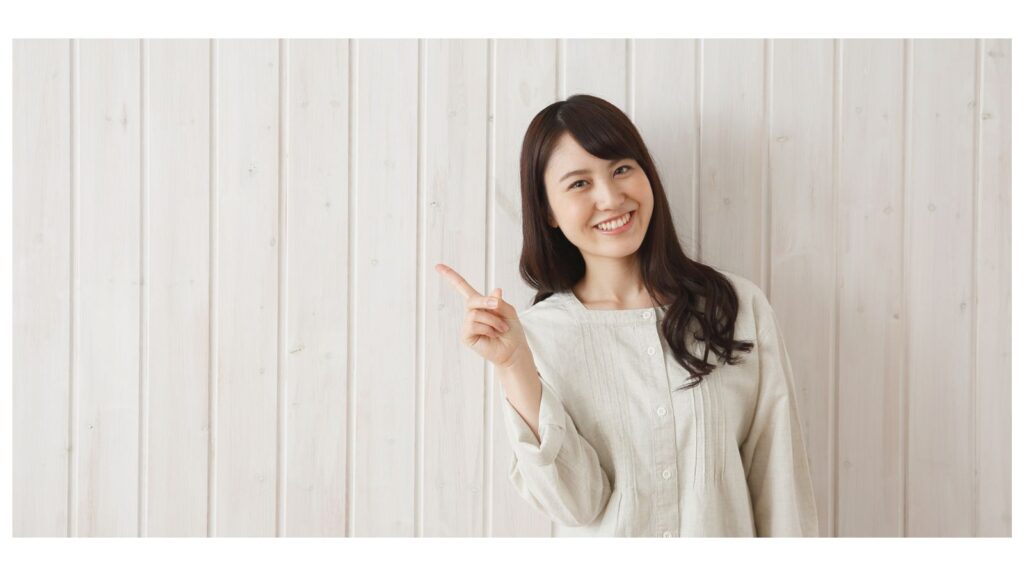 笑顔で指をさす女性。金運を引き寄せる整理整頓のポイントを紹介するイメージ。