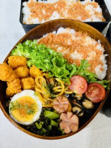 ささみのフライドチキン、ゆで卵、野菜が入った栄養バランスのいいお弁当